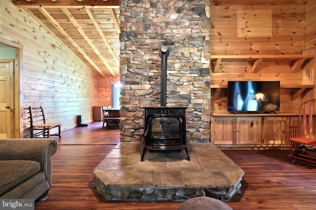 living room featuring a wood stove, vaulted ceiling with beams, dark hardwood / wood-style floors, wooden walls, and wood ceiling