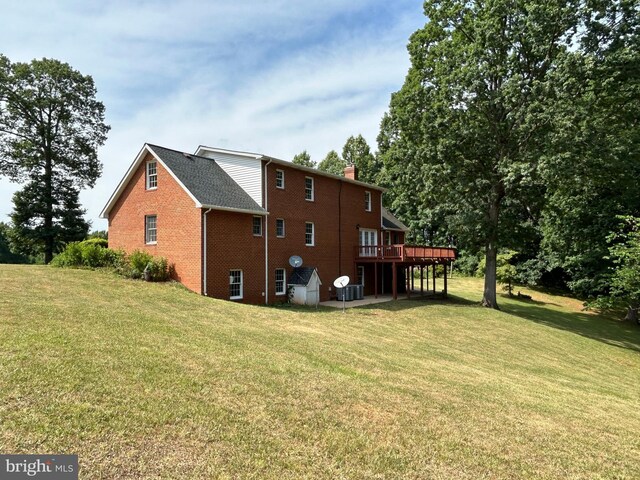 back of property with central air condition unit, a deck, and a yard