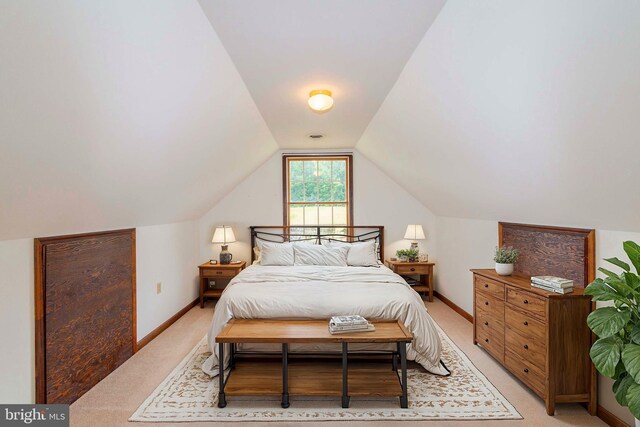 bedroom with vaulted ceiling and light colored carpet