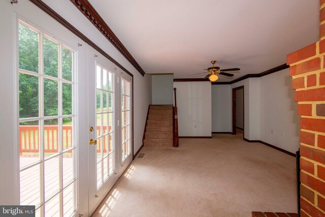 carpeted spare room featuring crown molding, plenty of natural light, and ceiling fan