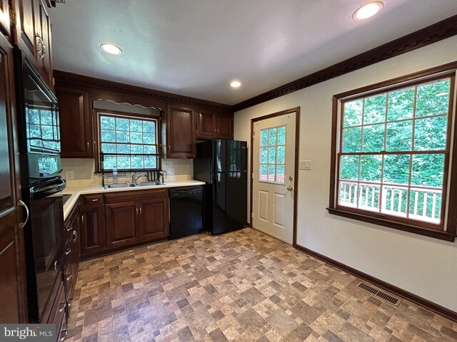 kitchen featuring crown molding, dark brown cabinets, sink, backsplash, and black appliances