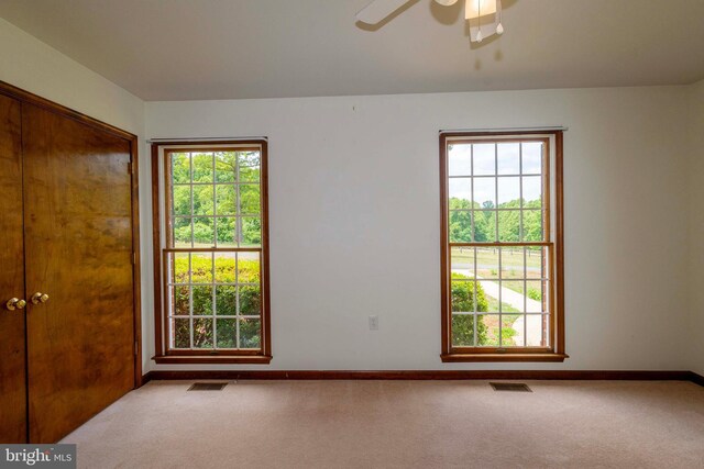 spare room with ceiling fan and carpet