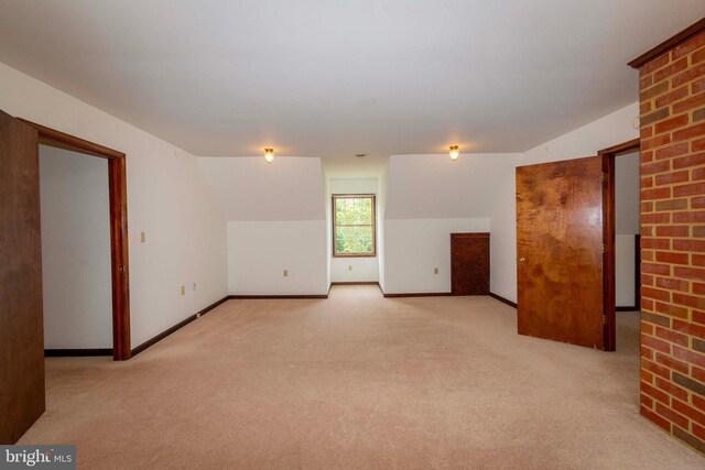 empty room with light carpet and lofted ceiling