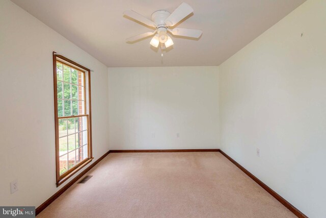 carpeted spare room featuring ceiling fan