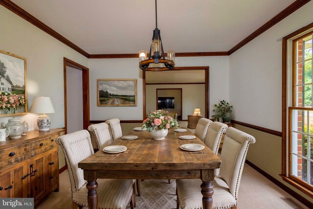 carpeted dining space featuring ornamental molding and a notable chandelier