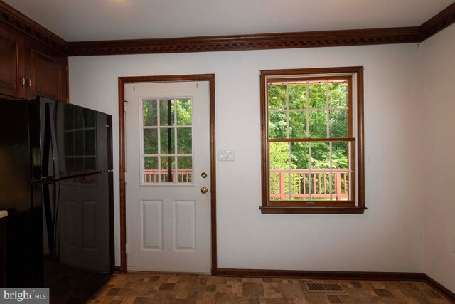 doorway to outside with ornamental molding and plenty of natural light