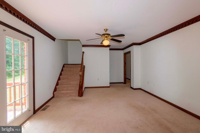 interior space with ceiling fan, light colored carpet, and crown molding