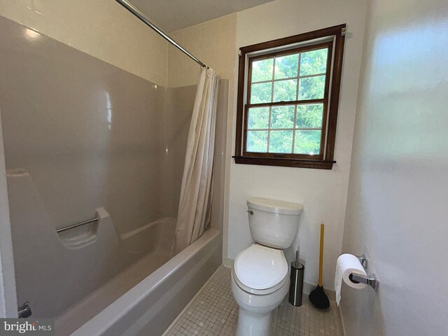 bathroom featuring toilet, shower / bath combination with curtain, and tile patterned floors