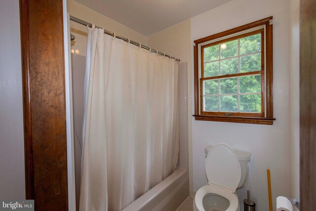 bathroom with toilet and shower / bathtub combination with curtain