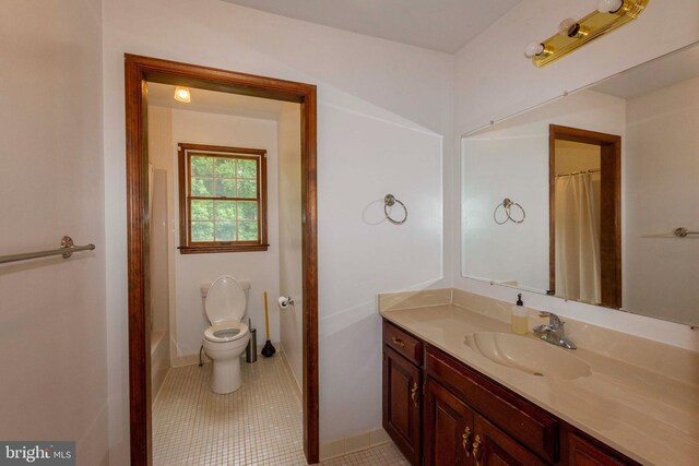 bathroom featuring tile patterned floors, vanity, and toilet