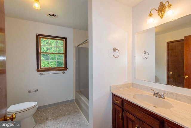 bathroom with toilet, vanity, and tile patterned flooring