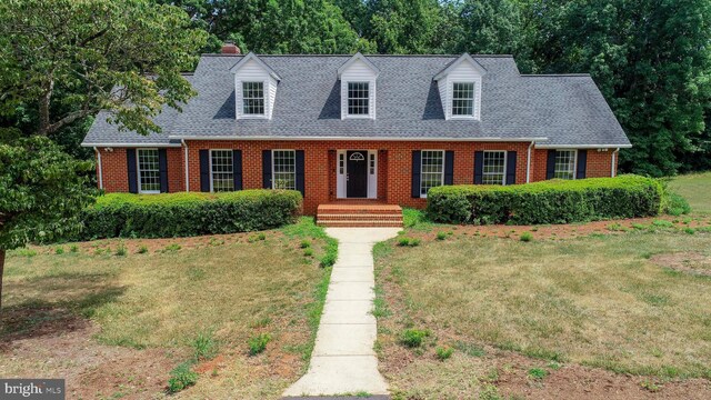 new england style home featuring a front yard