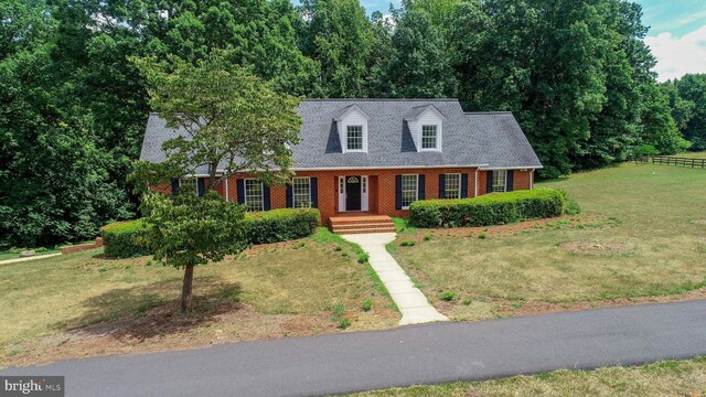 cape cod home with a front lawn