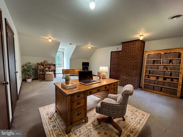 carpeted home office with vaulted ceiling