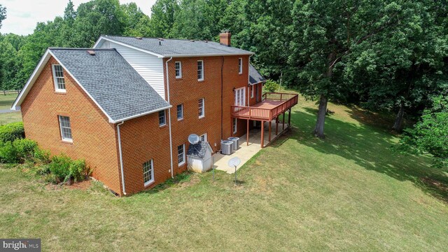 back of house with cooling unit, a lawn, and a wooden deck