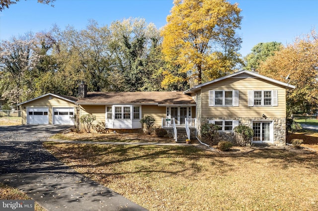 tri-level home with an outbuilding, a garage, and a front yard