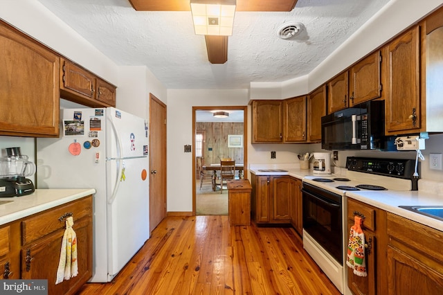 kitchen with light hardwood / wood-style flooring, ceiling fan, range with electric cooktop, a textured ceiling, and white fridge