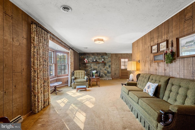 carpeted living room featuring crown molding, a textured ceiling, wooden walls, a fireplace, and a baseboard heating unit