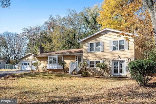 view of front of house featuring a garage and a front lawn