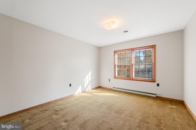 spare room with carpet flooring and a baseboard heating unit