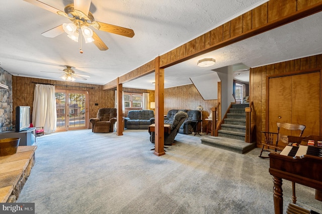 carpeted living room with a textured ceiling and wooden walls