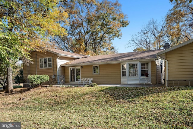 rear view of house featuring a patio and a lawn