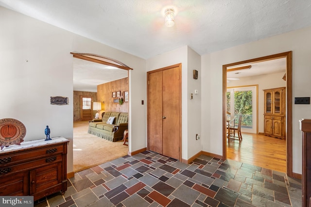 entryway featuring wooden walls and a textured ceiling