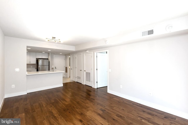 unfurnished living room with sink and dark hardwood / wood-style floors