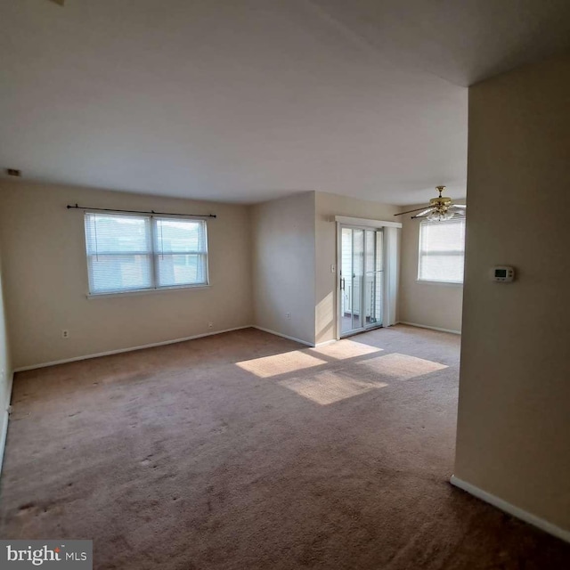 carpeted spare room featuring ceiling fan