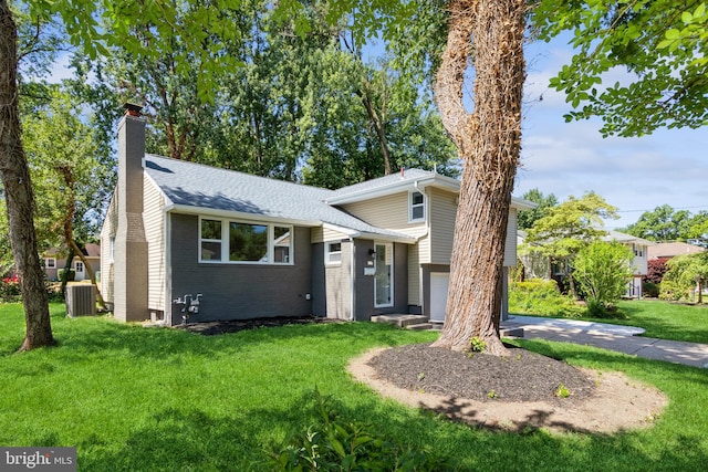 tri-level home with a garage, central air condition unit, and a front lawn