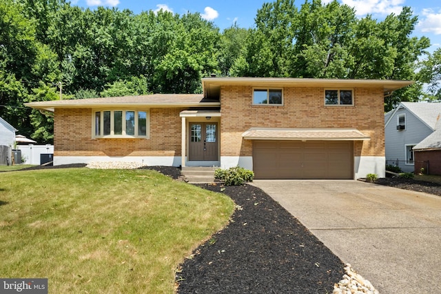 split level home featuring a garage and a front lawn