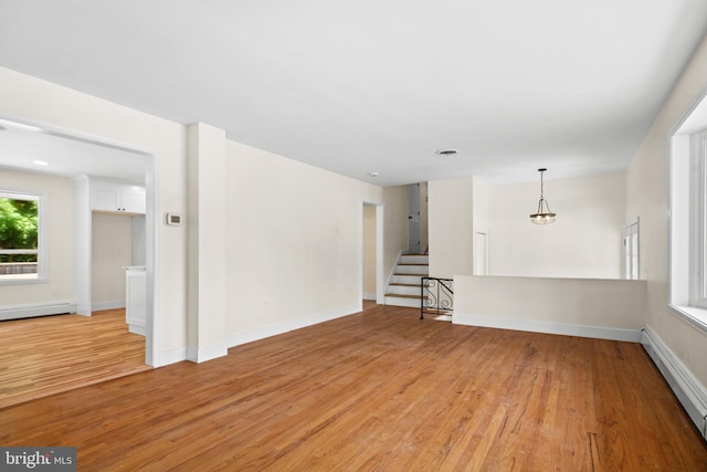 unfurnished room featuring a baseboard radiator and light wood-type flooring