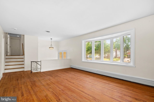 spare room featuring light wood-type flooring and a baseboard heating unit