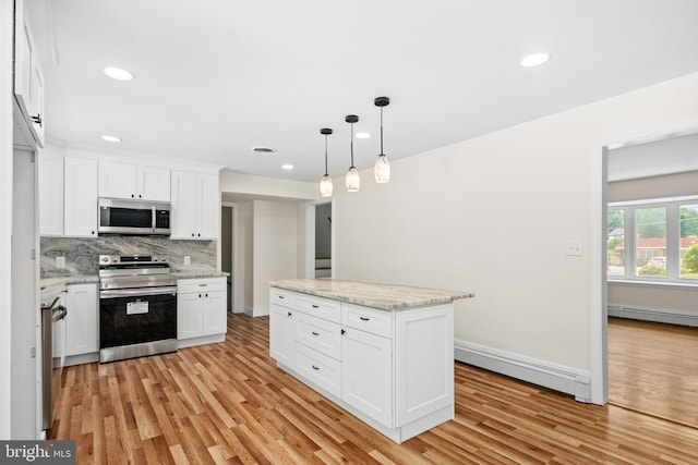 kitchen with pendant lighting, white cabinets, stainless steel appliances, and a baseboard heating unit