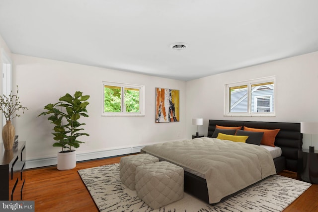 bedroom featuring wood-type flooring and baseboard heating