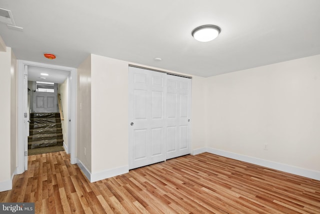 unfurnished bedroom with light hardwood / wood-style flooring and a closet