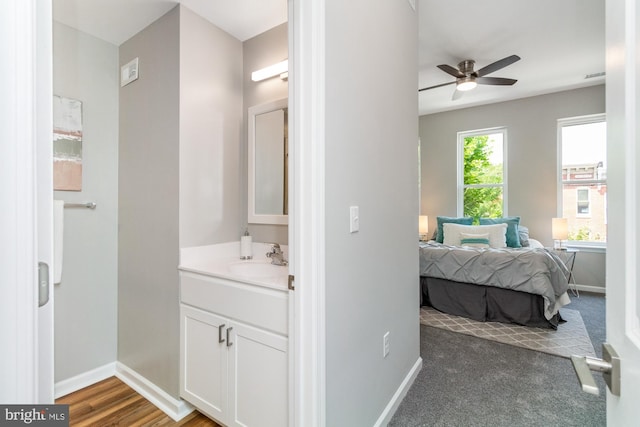 carpeted bedroom featuring ceiling fan and sink