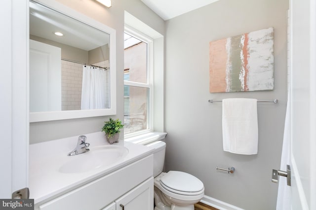 bathroom featuring a shower with shower curtain, vanity, and toilet