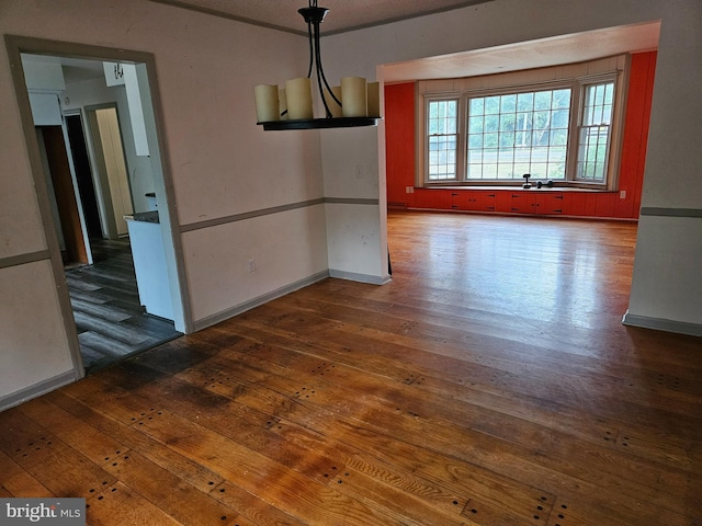 unfurnished dining area featuring a chandelier and dark hardwood / wood-style floors