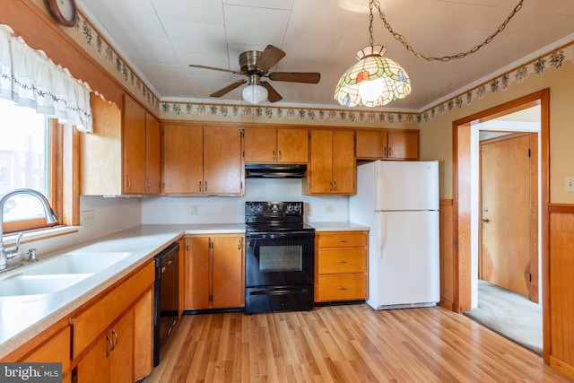 kitchen with ceiling fan, sink, hanging light fixtures, black appliances, and light wood-type flooring