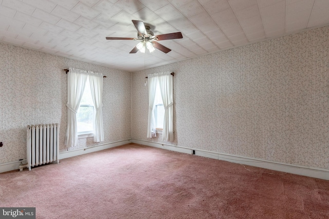 spare room with radiator, ceiling fan, and carpet floors