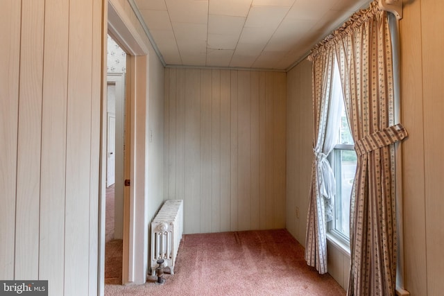 interior space featuring wood walls and radiator heating unit