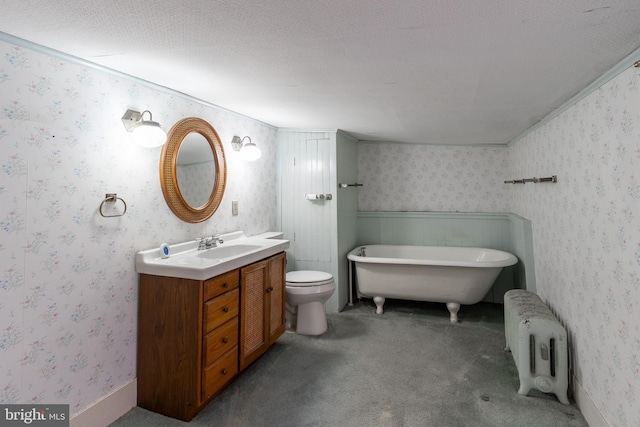 bathroom featuring radiator heating unit, a textured ceiling, toilet, a bathtub, and vanity