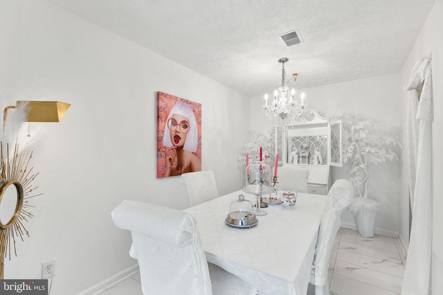 dining area with a chandelier and a textured ceiling