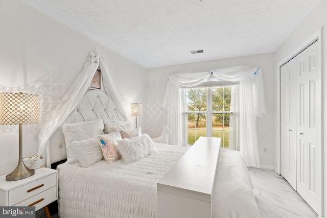 bedroom featuring a textured ceiling and a closet