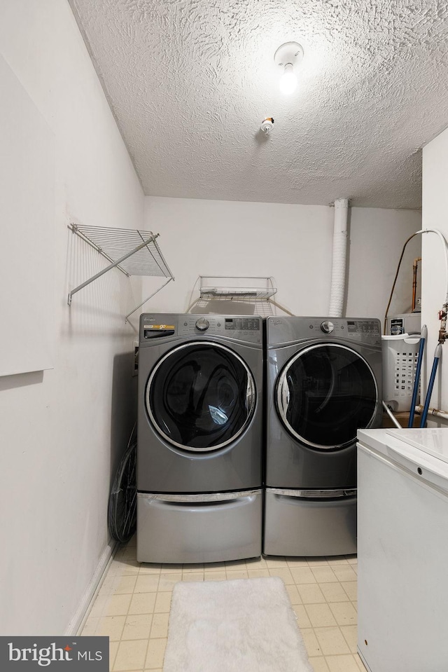 laundry room with separate washer and dryer and a textured ceiling