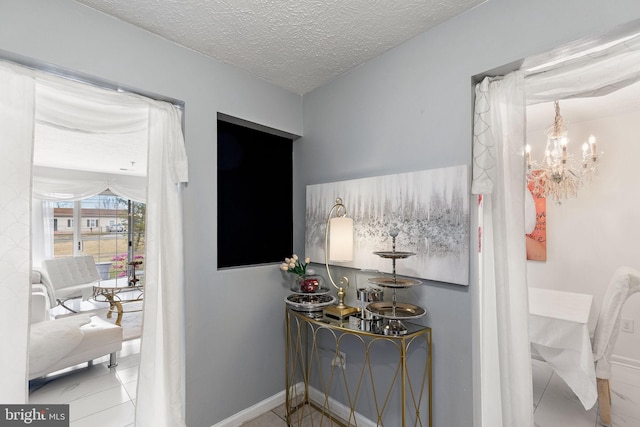 hallway with a notable chandelier and a textured ceiling