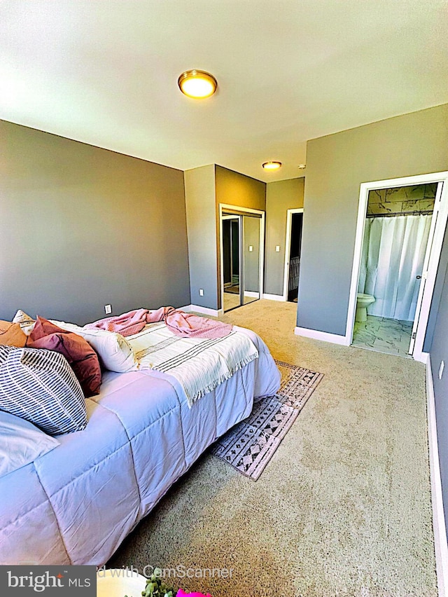 bedroom with ensuite bathroom and carpet