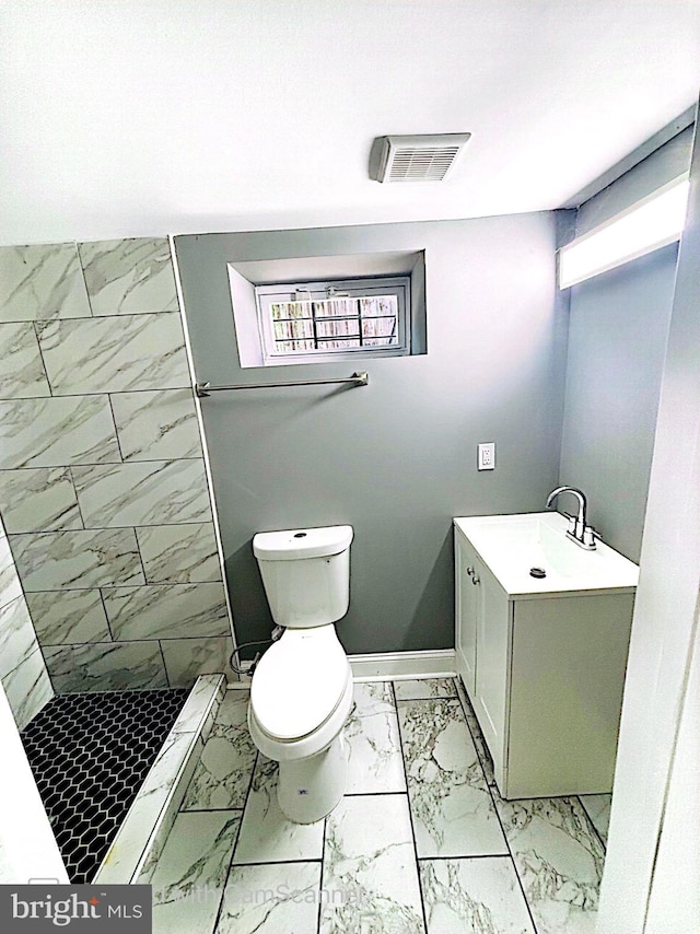 bathroom with a shower, vanity, and toilet