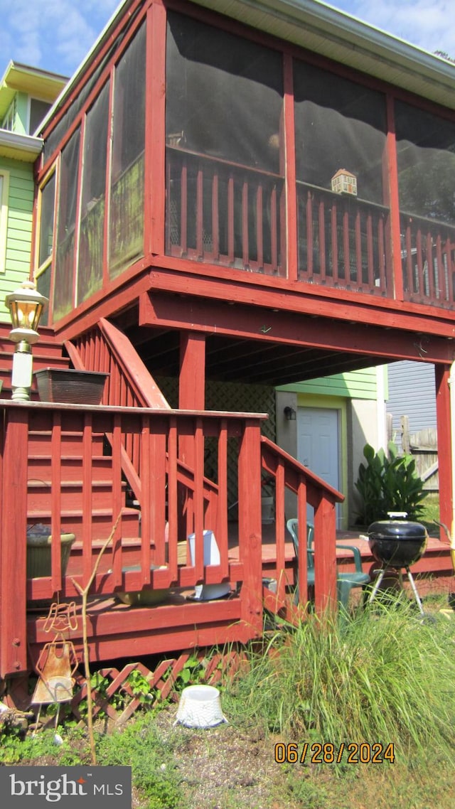 rear view of property with a deck and a sunroom